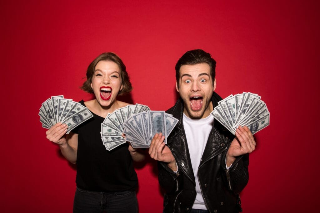 casal feliz segurando notas de dinheiro.